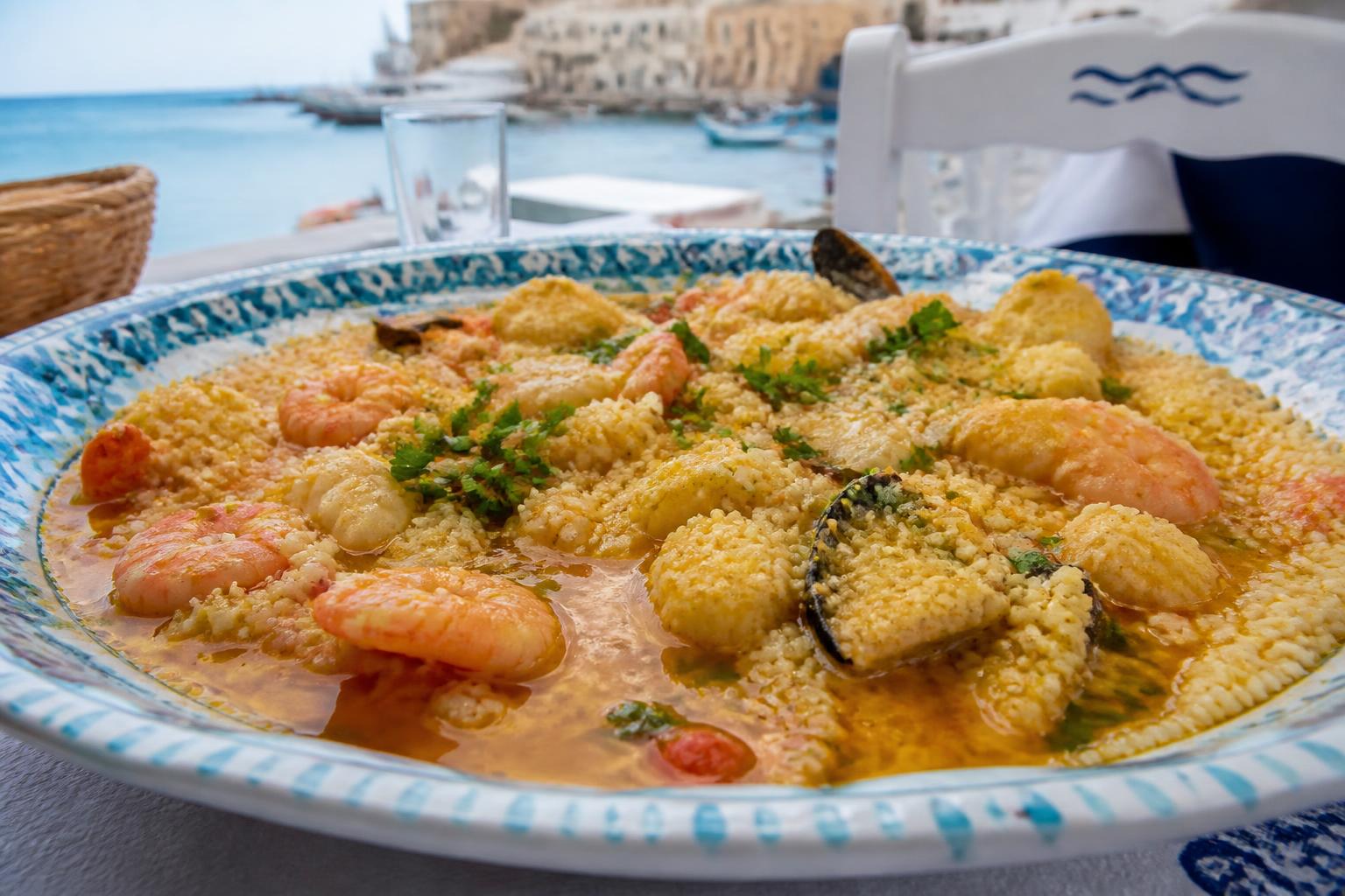 scopri la storia del cous cous trapanese, la ricetta tradizionale autentica e i migliori posti dove gustarlo in sicilia.